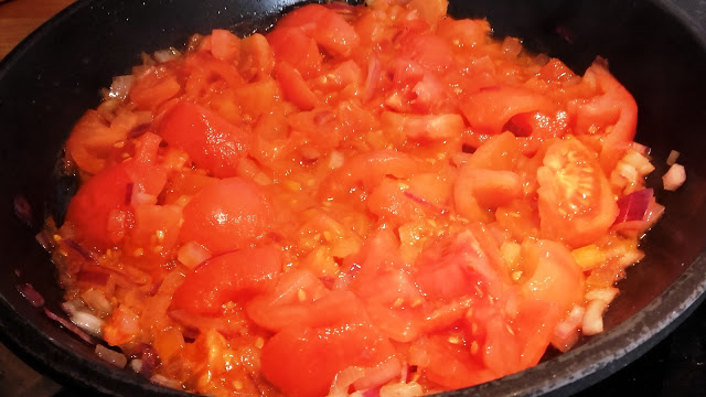 Smażenie pomidorów z cebulą.